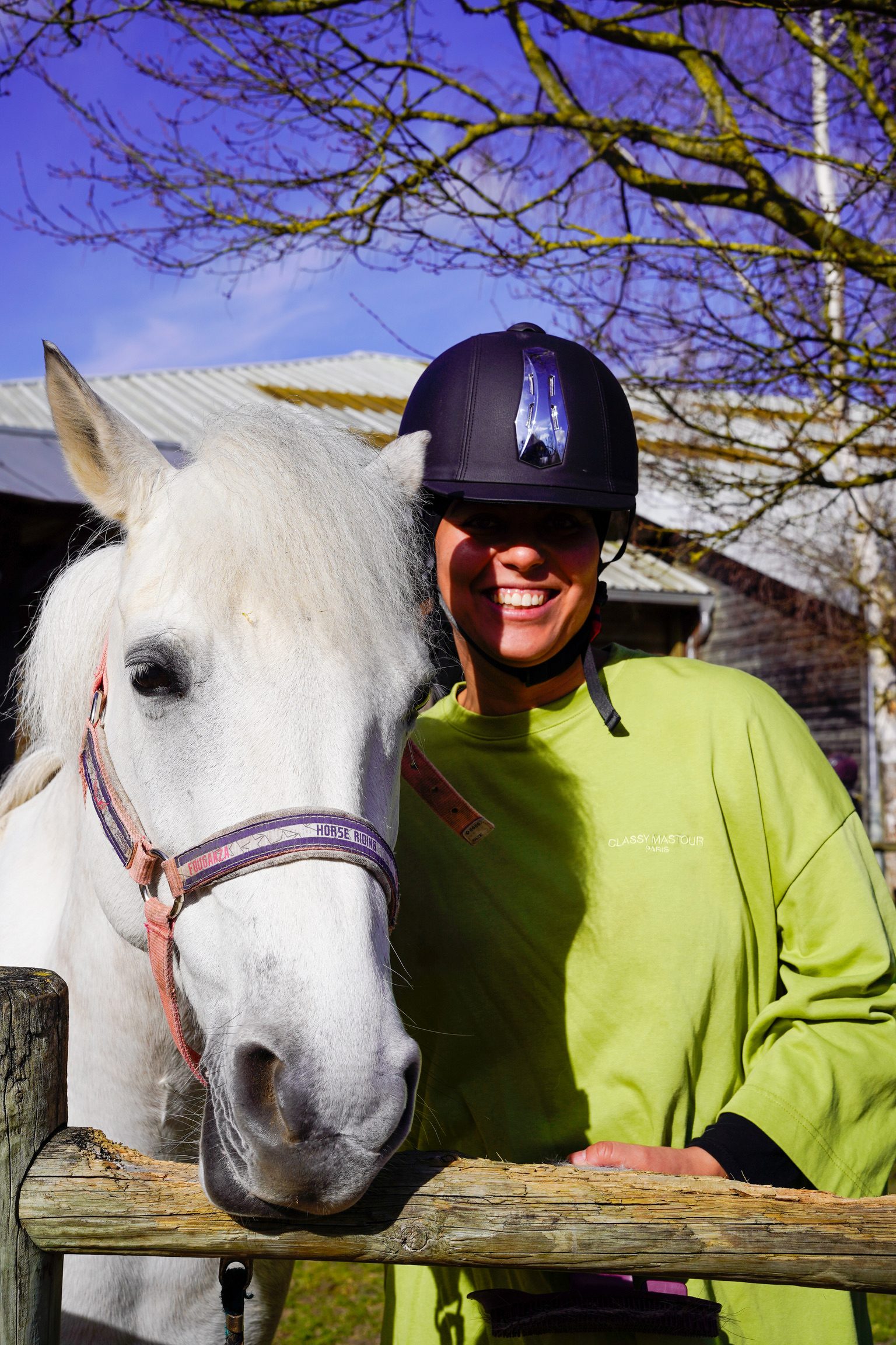Cavalière souriante avec un cheval blanc lors d'une sortie équitation